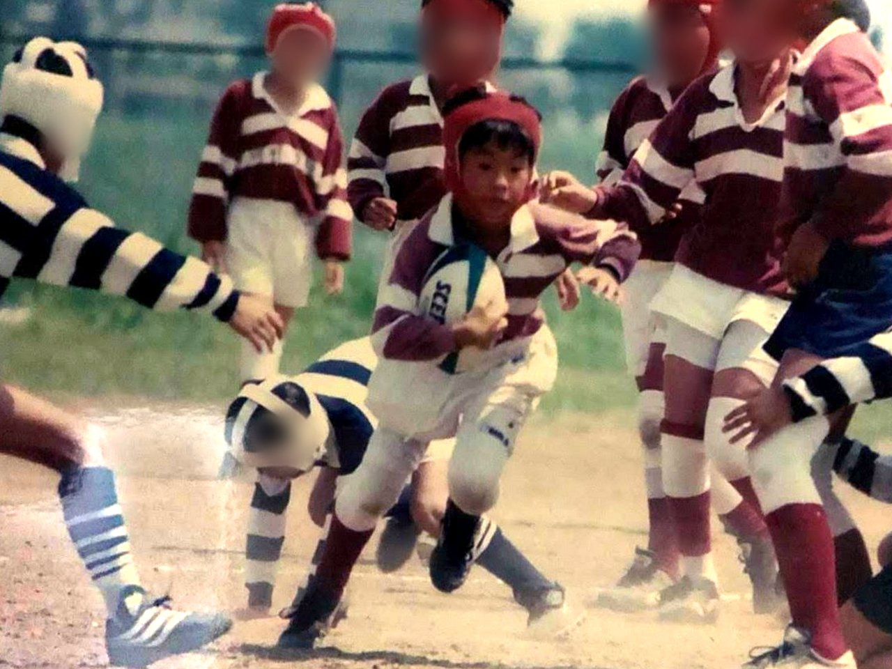 小学生時代、ラグビーの試合でボールを持って走る須田英太郎